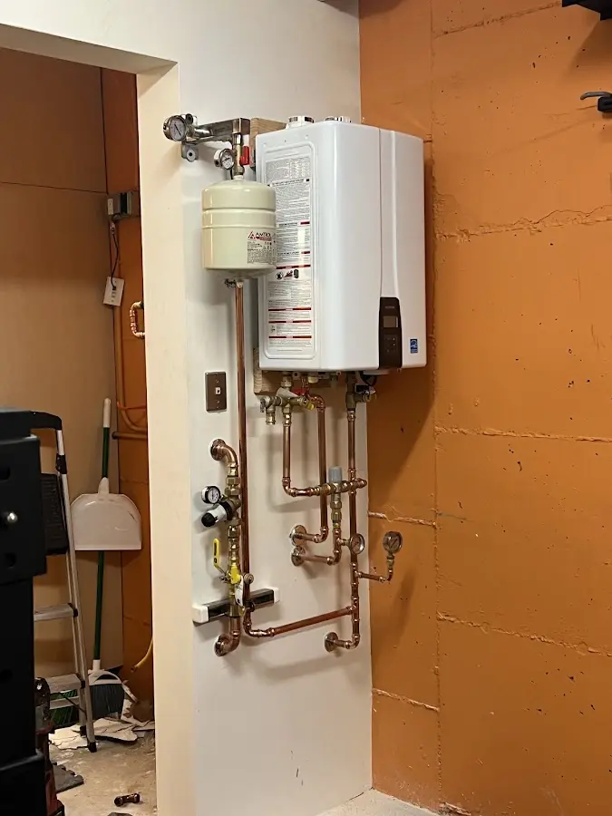 Plumbing technician inspecting water heater connections in Hamden